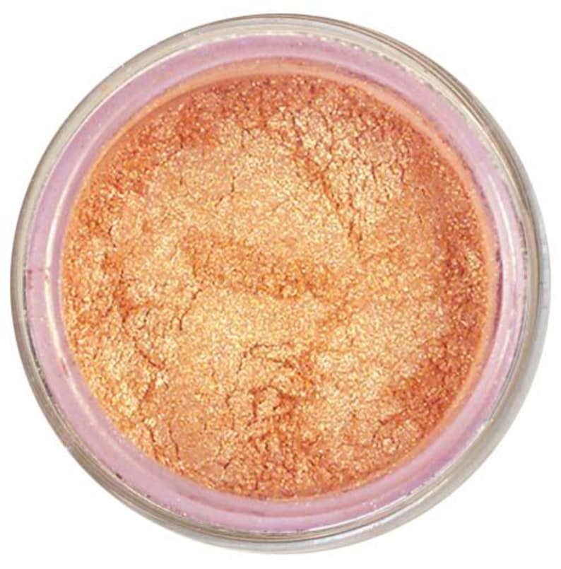 May include: A small jar of shimmering copper mica powder. The powder is a fine, loose texture and has a metallic sheen.