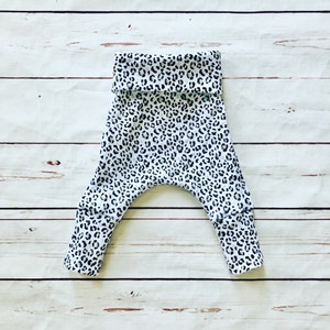 May include: White and black leopard print baby leggings with a fold-over waistband.