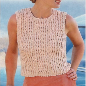 May include: A woman wearing a pink sleeveless knitted top with a white hat and a coral skirt.