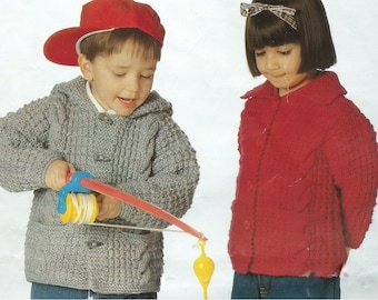 Op de afbeelding: Twee kinderen dragen gebreide truien. Het kind links draagt een grijze trui met een capuchon en een rode baseballpet. Het kind rechts draagt een rode trui met een witte strik in haar haar. Het kind links houdt een speelgoedhengel vast.