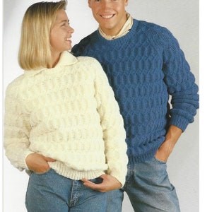 May include: Two sweaters, one white and one blue, with a textured knit pattern. Both sweaters have a crew neck and long sleeves.