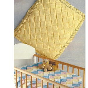 May include: A yellow knitted baby blanket with a crocheted border, hanging above a crib with a teddy bear and a multi-colored blanket inside.