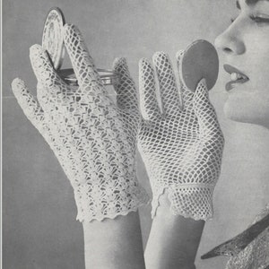 Könnte beinhalten: Ein Paar weiße Häkelhandschuhe mit einem zarten Spitzenmuster. Die Handschuhe werden von einer Person getragen, die sich schminkt.