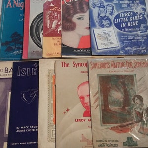 May include: A collection of vintage sheet music featuring titles like "A Night in the Latin Quarter", "Isle", "The Syncopated Dance", and "Somebody's Waiting for Someone". The covers feature illustrations of people, landscapes, and musical instruments.