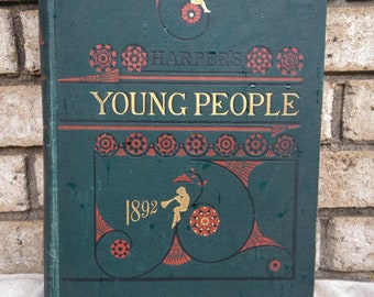 以下が含まれることがあります： 「Harper's Young People」と「1892」という金色の文字が書かれた緑色のハードカバーの本。表紙には、本を読んでいる人の小さなイラストと、複雑な赤と金のデザインが施されています。