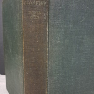 Puede incluir: Un libro antiguo de tapa dura titulado "Analytic Geometry" de Tanner y Allen. El libro tiene una cubierta verde oscuro con un lomo marrón.