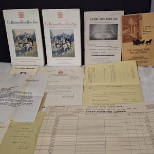Puede incluir: Una colección de efímeras de espectáculos ecuestres antiguos, incluyendo programas y formularios de inscripción. Los programas presentan ilustraciones de jinetes y caballos. El texto incluye "The Richmond Royal Horse Show" y "Eastern Show Horse Sale."