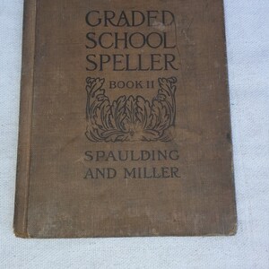 May include: A brown book with the title "GRADED SCHOOL SPELLER BOOK II SPAULDING AND MILLER" printed on the cover.
