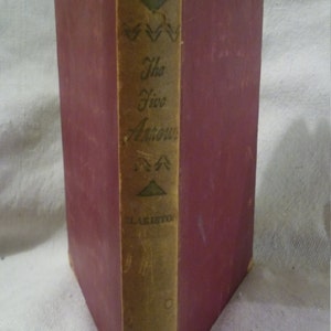May include: A vintage hardcover book with a burgundy cover and a spine with a tan label. The label has the text "Allan Chase" and "The Five Arrows" in black lettering. The label also has a small green triangle and three green arrows.