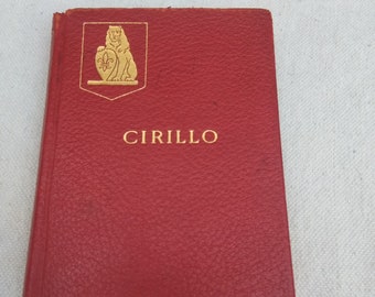 May include: A red leather-bound book with gold lettering. The title is "CIRILLO" and the author is "EFFIE DOUGLAS PUTNAM". The cover features a gold illustration of a lion.