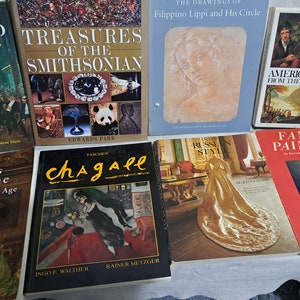 May include: A collection of nine hardcover books about art and painting. The books feature a variety of subjects, including famous paintings, the Smithsonian, and the lives of the rich. The books are arranged in a row on a white surface.