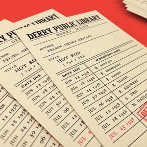 May include: A stack of cream-colored library checkout cards from the Derry Public Library, Maine. Each card lists the author Felsen, Henry Gregor, the title Hot Rod, and a table with columns for date due and borrower's name, with a red returned stamp.