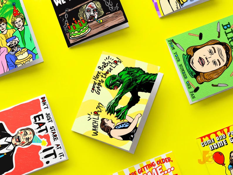 May include: A collection of rectangular greeting cards featuring colorful pop-art style illustrations. Designs include a green creature reaching for a person, a person with a party hat, and various text captions like EAT IT and GIMME those Lips.