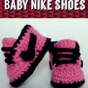 May include: A pair of pink and black crocheted baby shoes with a Nike swoosh design. The shoes are made with a soft yarn and have a black trim around the edges.