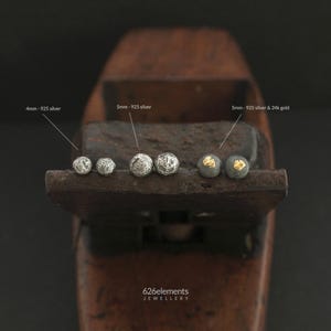 May include: Three pairs of stud earrings with textured surfaces. The first pair is 4mm 925 silver, the second is 5mm 925 silver, and the third is 5mm 925 silver with 24k gold accents. The text 626elements JEWELLERY is visible at the bottom.