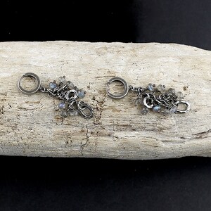 Peut inclure: Une paire de boucles d'oreilles cr&eacute;oles en argent avec des breloques pendantes et des pierres iris&eacute;es.