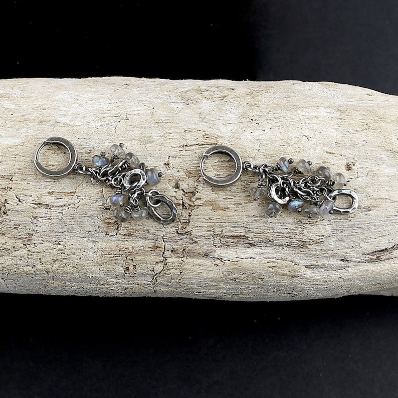 Peut inclure: Une paire de boucles d'oreilles cr&eacute;oles en argent avec des breloques pendantes et des pierres iris&eacute;es.