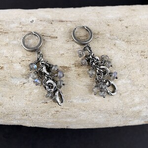 Peut inclure: Une paire de boucles d'oreilles pendantes en argent avec un groupe de pierres de labradorite iris&eacute;es et des accents en m&eacute;tal martel&eacute;.