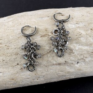 Peut inclure: Une paire de boucles d'oreilles pendantes en argent avec un groupe de pierres iris&eacute;es et des maillons de cha&icirc;ne en argent.