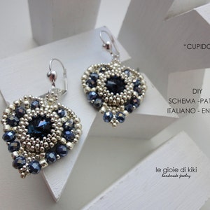 Può includere: Un paio di orecchini a forma di cuore argentati e blu con un design a perline. Gli orecchini sono etichettati "CUPIDO" e "DIY SCHEMA-PATTERN ITALIANO - ENGLISH".