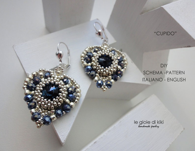 Może przedstawiać: Para srebrnych i niebieskich kolczyk&oacute;w w kształcie serca z koralikowym wzorem. Kolczyki są oznaczone "CUPIDO" i "DIY SCHEMA-PATTERN ITALIANO - ENGLISH".