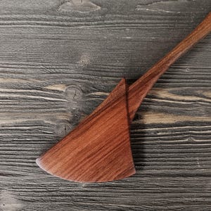 Close-up of walnut wood spatula blade showing rich dark brown grain and smooth hand-sanded finish