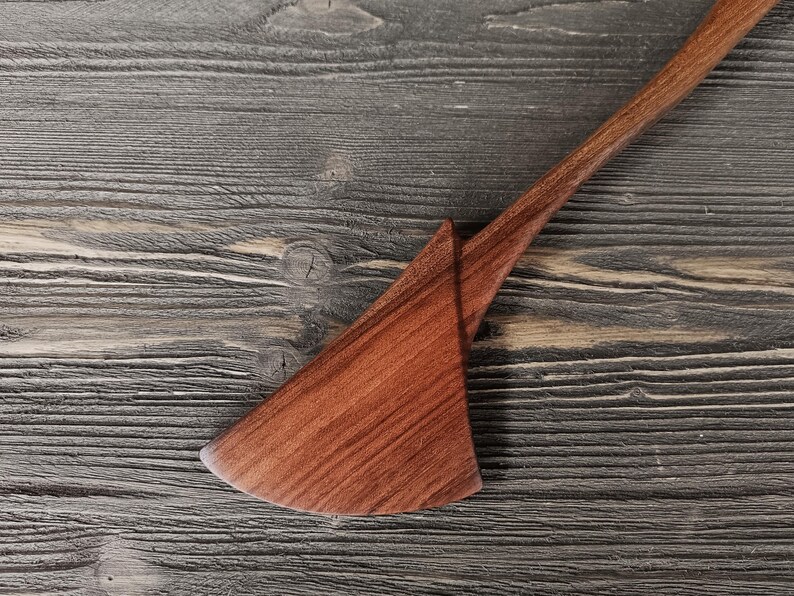 Close-up of walnut wood spatula blade showing rich dark brown grain and smooth hand-sanded finish
