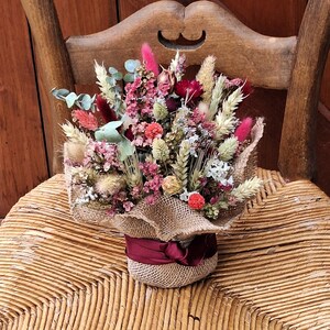 dried flower arrangement. gift home decoration. shades of deep reds to deep pinks. natural, ivory. grasses hydrangea. hessian overlay