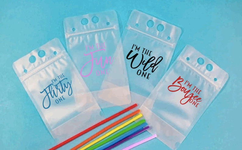 May include: Four clear plastic drink pouches with zipper closures and three holes for straws. Each pouch has a different phrase printed on it: "I'm the flirty one", "I'm the fun one", "I'm the wild one", and "I'm the boujee one".