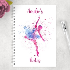 May include: A white notebook with a pink watercolour ballerina illustration and the text "Amelie's Notes".