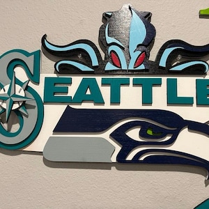 Laser cut Seattle sports teams. Kraken, Mariners, and Seahawks.  3d sign with many layers