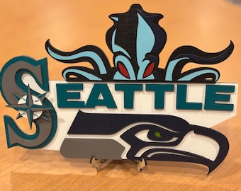 Laser cut Seattle sports teams. Kraken, Mariners, and Seahawks.