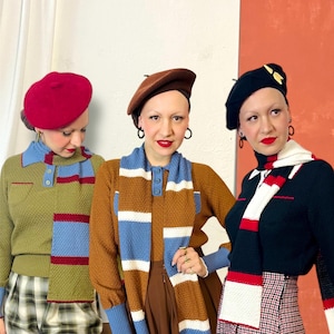Puede incluir: Tres personas con prendas de punto y boinas de estilo vintage. Los conjuntos incluyen suéteres, bufandas y boinas en varios colores como rojo, marrón, azul y negro. Los conjuntos tienen una estética retro.