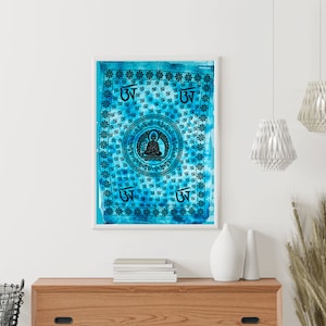 May include: A blue and white tapestry with a mandala design featuring a seated Buddha figure in the centre. The mandala is surrounded by repeating symbols and floral patterns.