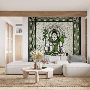 May include: A green and white tapestry depicting a deity with a third eye, seated in a meditative pose. The tapestry has a decorative border with repeating patterns.