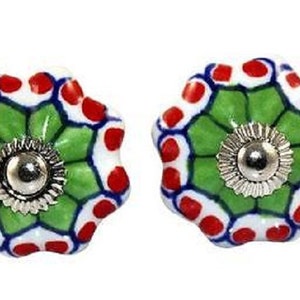 May include: Two decorative ceramic cabinet knobs. Each knob has a floral design with a green center, white petals with red dots, and a silver metal base. These knobs are perfect for adding a pop of color to any cabinet or drawer.