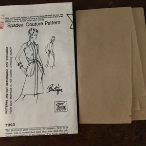 May include: A vintage sewing pattern for a sleeveless shirtwaist dress. The pattern is from Spadea Couture and is size 14. The pattern includes instructions for a top-stitched band that runs from the collar to the hemline. The text on the pattern reads "Patterns are not returnable for exchange. Note size stamped in red before unfolding pattern. This pattern is pre-cut and prepared for your convenience. Detailed instructions are on the reverse side of this chart. Please check for desired length before cutting. Spadea Couture Pattern. Boutique. New Sizing Plus. 71193. The shirtwaist goes sleeveless for summer. Here it is shown with a top-stitched band that runs from the collar and sewn neckline to the hemline. The band, stitched"