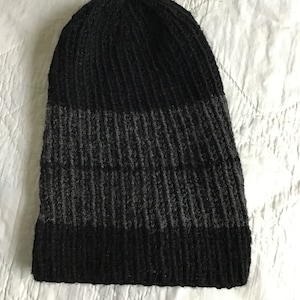 May include: Black and gray knit beanie with a ribbed texture.
