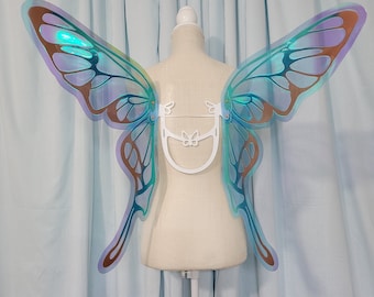 May include: A pair of iridescent blue and brown butterfly wings with a white plastic frame. The wings are attached to a white mannequin.