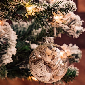 Globo de cristal con páginas antiguas de la Biblia, colgante de cruz y tarjeta con cita religiosa. Ideal como regalo de Navidad.