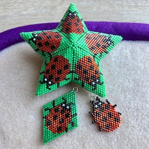 Peut inclure: Ensemble d'ornements perlés sur le thème de la coccinelle. L'ensemble comprend une étoile verte, une pièce en forme de losange et une figurine de coccinelle. Chaque pièce présente un fond vert avec des détails de coccinelles rouges et noires. Les ornements sont probablement faits à la main.