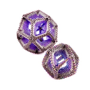 May include: Two purple and silver geometric bead ornaments with a woven design.