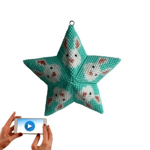 May include: A teal blue star-shaped ornament with white bunny faces and brown ears. The ornament is made of beads and has a loop at the top for hanging.