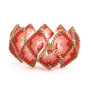 Może przedstawiać: Bransoletka z czerwonych i złotych koralików o geometrycznym wzorze. Bransoletka wykonana jest z małych, kwadratowych koralików ułożonych w wzór nakładających się kwadratów.