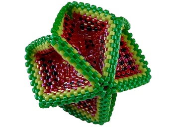 Puede incluir: Un cubo de cuentas verde, amarillo y rojo con un patrón de sandía. El cubo está hecho de pequeñas cuentas que se tejen juntas para crear una forma tridimensional.