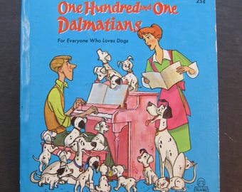 May include: A vintage children's book titled "One Hundred and One Dalmatians" with a blue cover. The cover features illustrations of Dalmatian dogs, a woman, and a man playing a pink piano. The text "For Everyone Who Loves Dogs" is also visible.