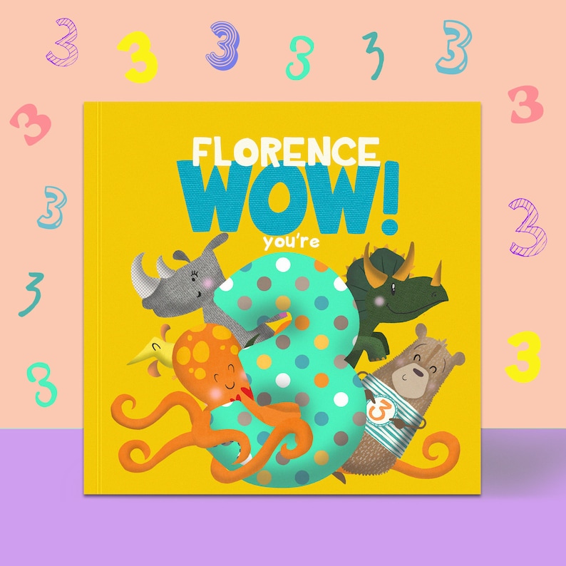 May include: A children's book with a yellow cover featuring the text "FLORENCE WOW! you're 3". The number 3 is decorated with polka dots and surrounded by cartoon animals, including a rhino, octopus, and bear. The background is a light pink.