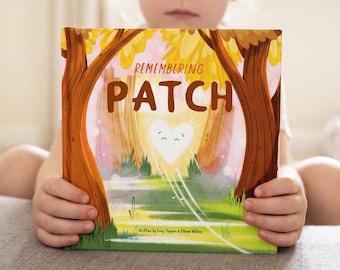 Peut inclure: Un livre pour enfants intitulé Remembering Patch avec une illustration de couverture représentant un cœur blanc brillant dans une forêt. Le titre est imprimé en grandes lettres brunes et les auteurs sont Lucy Topper et Steve Wilson.
