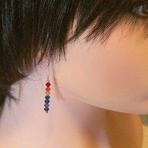May include: Rainbow crystal earrings with silver hooks. The crystals are red, orange, yellow, green, blue, and indigo.
