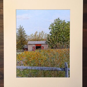 May include: A painting of a stone barn with red doors, surrounded by tall grass and trees. The barn is set against a blue sky with white clouds. A wooden fence is in the foreground.